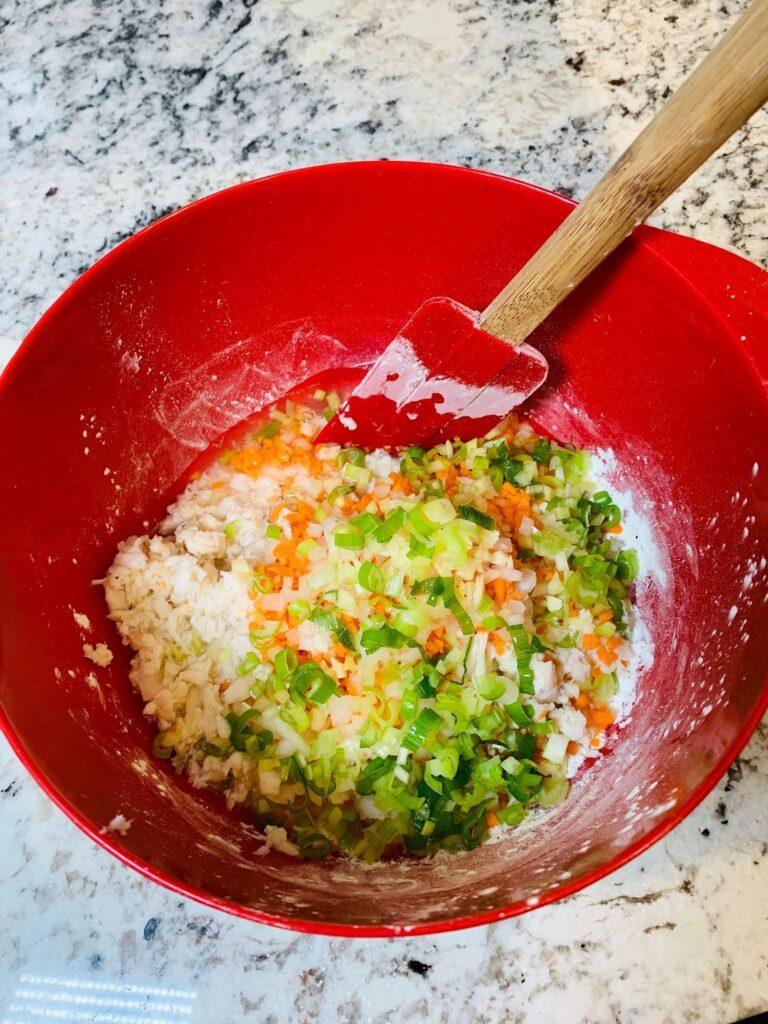 8 Easy Steps to Make the Best Tilapia Fish Ball Recipe at Home Tilapia fish ball recipe step showing chopped onions, garlic, carrots, and green onions mixed with water into a sticky batter.