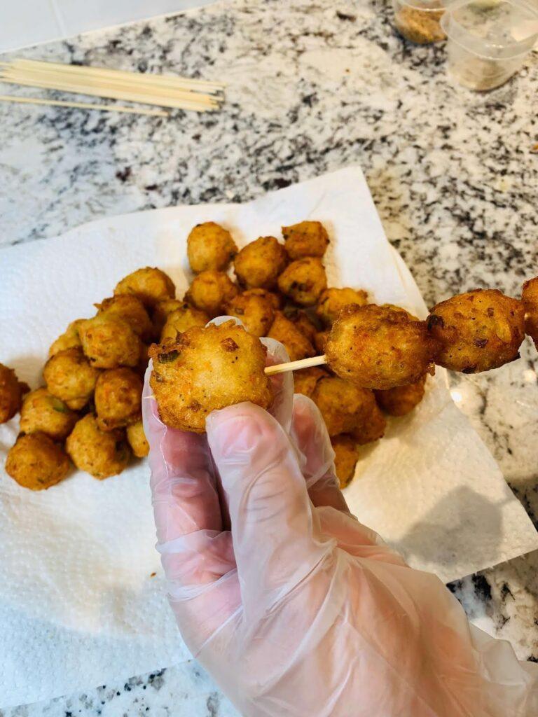 8 Easy Steps to Make the Best Tilapia Fish Ball Recipe at Home Tilapia fish ball recipe step showing golden fried fish balls placed on bamboo skewers and prepared for serving with dipping sauces.