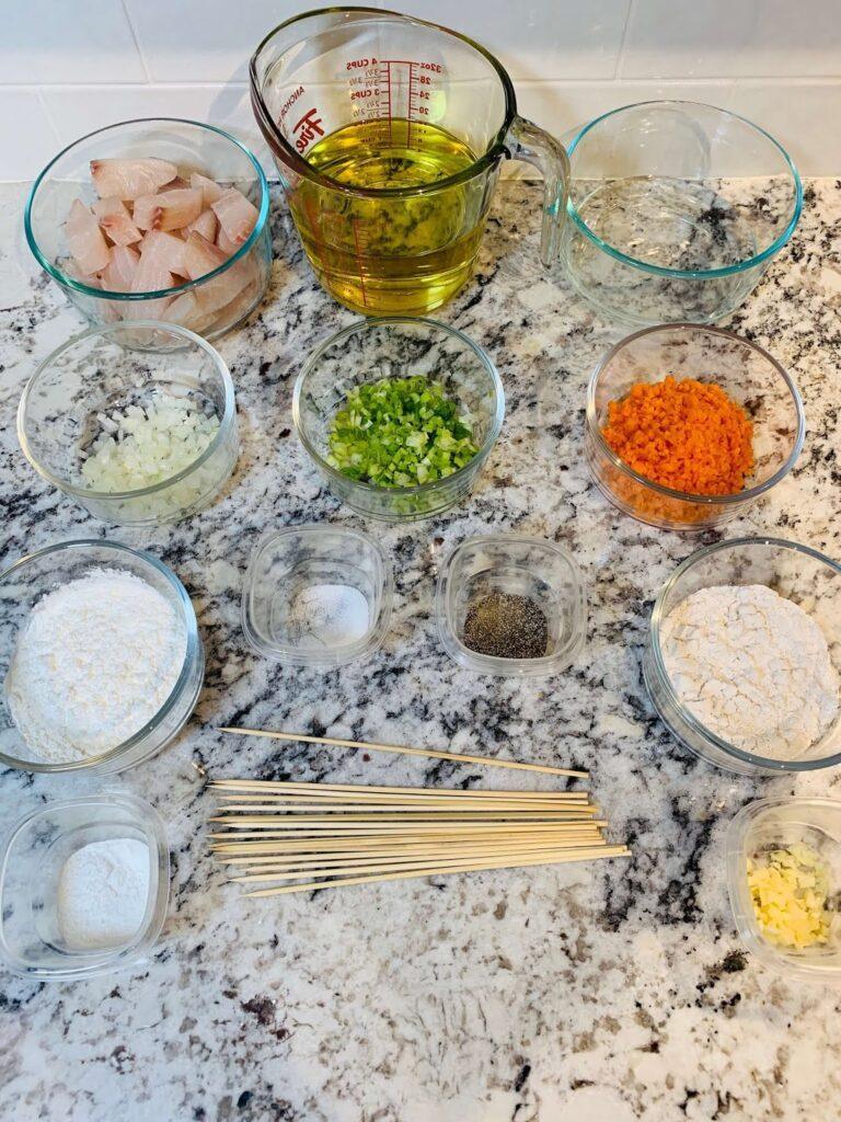 8 Easy Steps to Make the Best Tilapia Fish Ball Recipe at Home Tilapia fish ball recipe main ingredients arranged on a countertop, including chopped vegetables, seasonings, flour, and fresh tilapia pieces prepared for mixing.