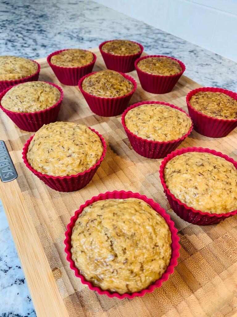 12 Soft & Moist Steamed Banana Cupcakes (No Oven Needed) – Easy Pinoy Merienda Recipe for Busy Families Soft and moist steamed banana cupcakes in red silicone molds on a wooden board, a popular Filipino merienda snack.