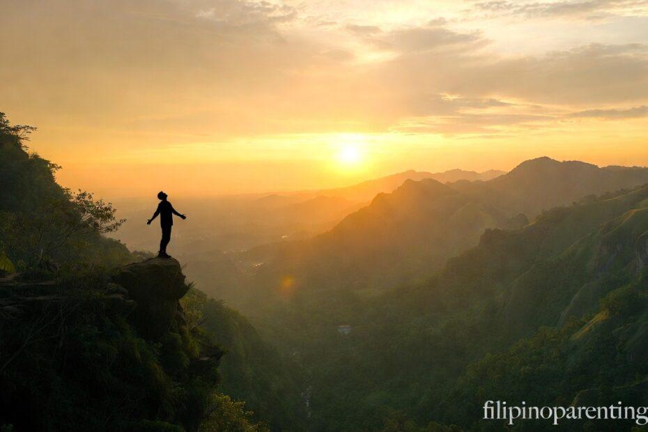 A person standing tall on a mountain peak representing Inspirational Tagalog Quotes for Self-Worth and Pride.