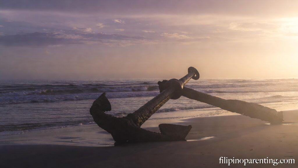 Tagalog Christian Wisdom Navigating Uncertainty: 5 Unshakeable Truths An anchor on a beach at sunrise representing Tagalog Christian Wisdom Navigating Uncertainty.