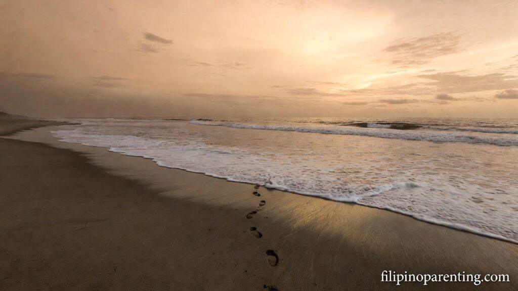 Tagalog Quotes on God’s Endless Mercy and Grace: 5 Eternal Truths Waves washing footprints on a beach at dawn representing Tagalog Quotes on God’s Endless Mercy and Grace.