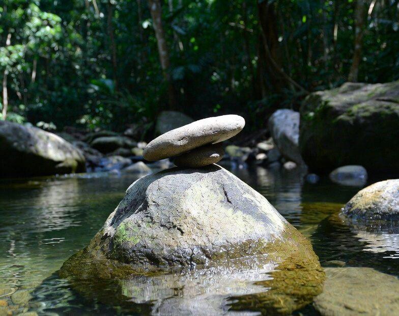 Balanced stones in a clear stream representing Tagalog Sayings Finding Calm Stillness Clarity.